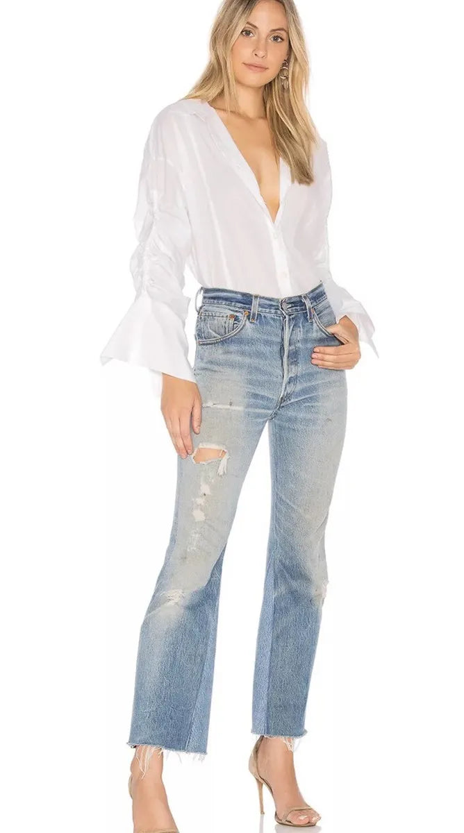 a free people button down white shirt paired with distressed denim