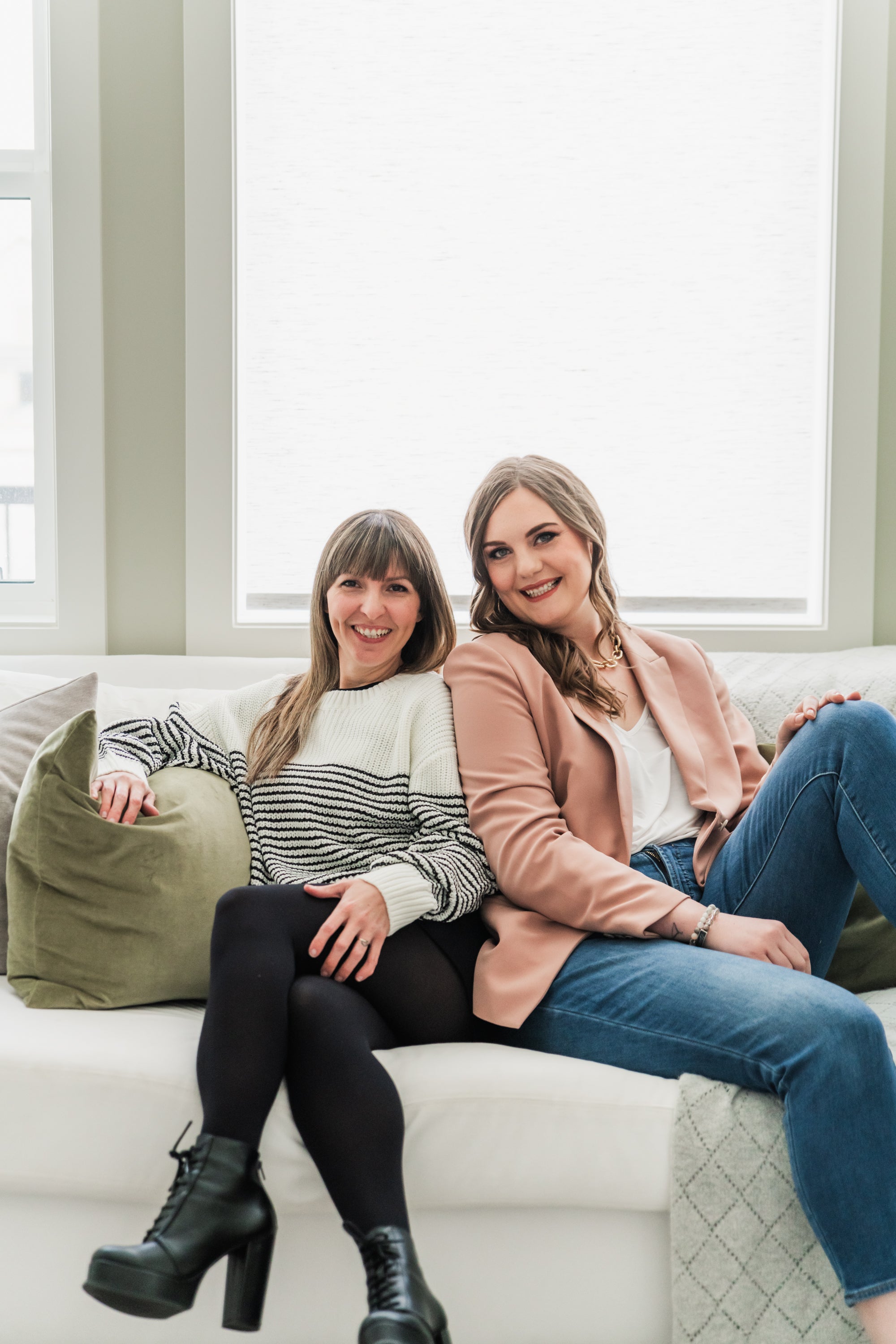 two female business owners sitting on the couch smiling 