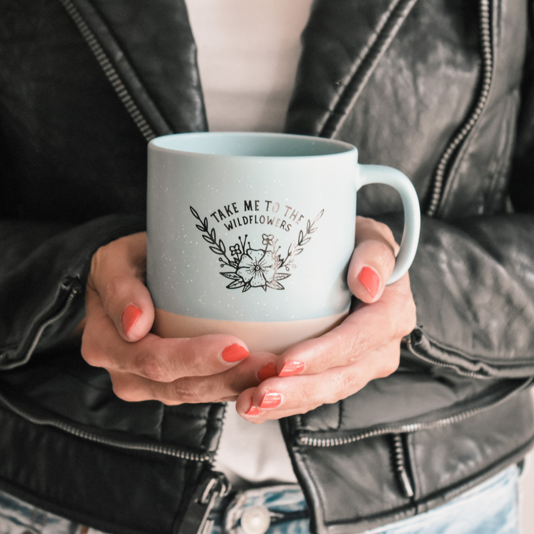 a mug made by a local maker, placed in the hands of a woman