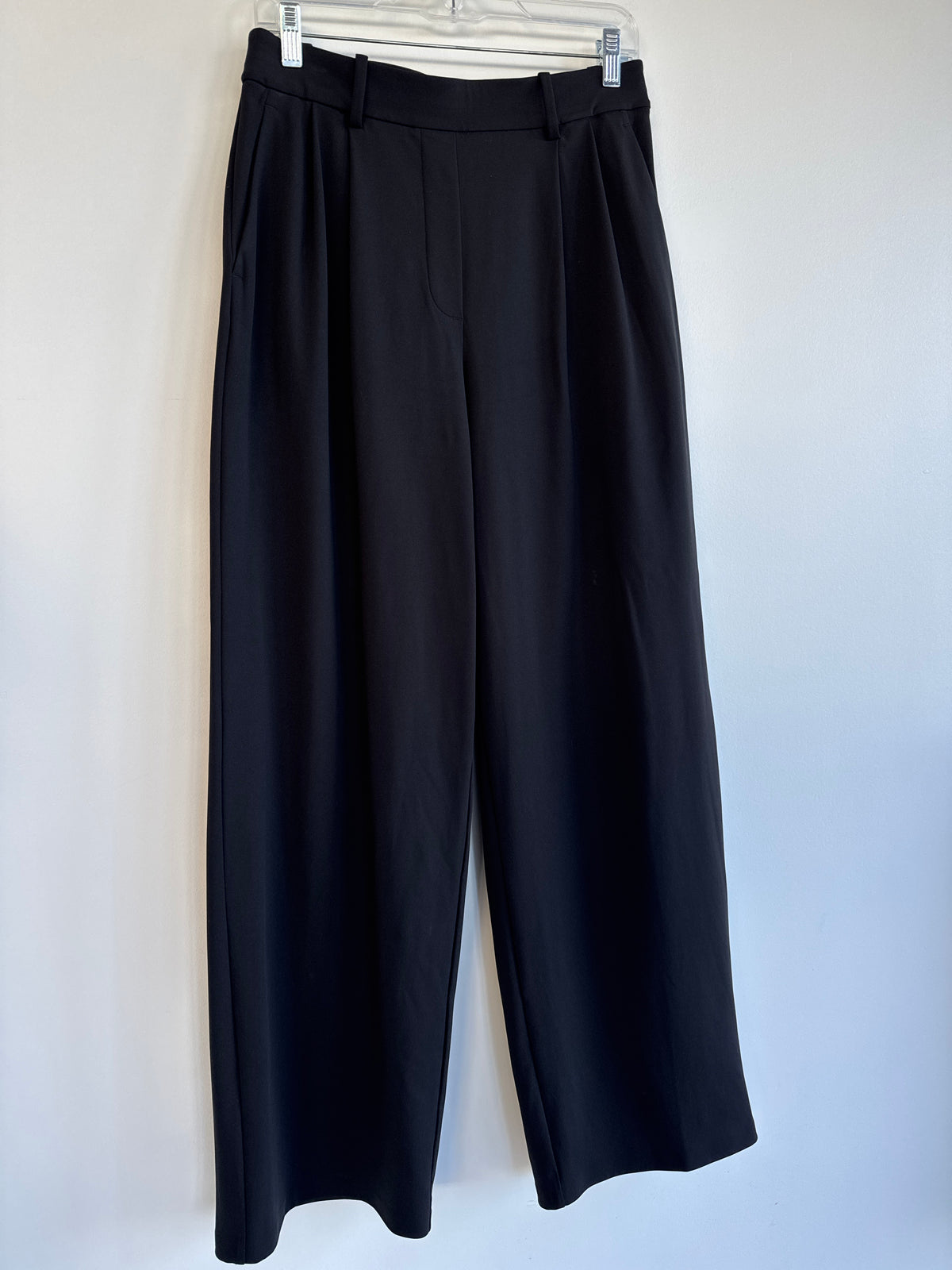 Black wide-leg cropped lululemon trousers hanging on a white hanger against a plain light gray wall. Sherwood Park consignment, Sherwood Park shopping, consignment store Sherwood Park, Edmonton consignment, secondhand shopping, secondhand clothing, women’s consignment, women’s clothing consignment, curated consignment, quality secondhand clothing, pre-loved clothing, thrift shopping, sustainable fashion, local shopping, Alberta consignment