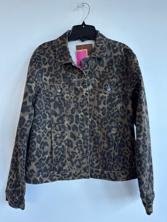 A leopard print denim jacket hanging on a black hanger against a plain light gray wall. The jacket features a brown and black animal print pattern with a button-up front and two chest pockets. Judy Blue. Sherwood Park consignment, Sherwood Park shopping, consignment store Sherwood Park, Edmonton consignment, secondhand shopping, secondhand clothing, women’s consignment, women’s clothing consignment, curated consignment, quality secondhand clothing, pre-loved clothing, thrift shopping, sustainable fashion, l