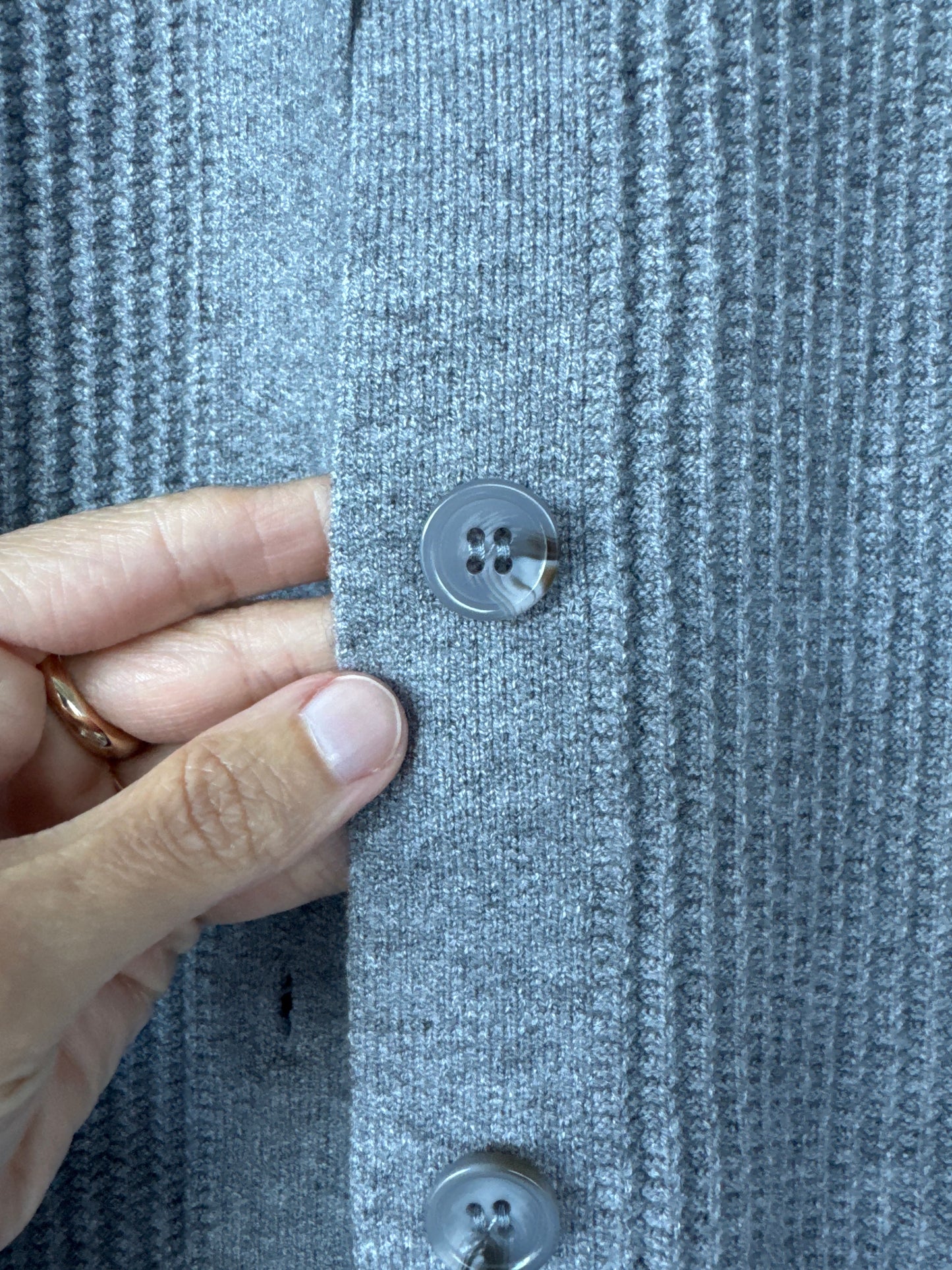 Close-up of a gray ribbed knit cardigan or sweater with dark gray buttons, shown with a hand pointing to the fabric texture.
edmonton consignment, sherwood park consignment, secondhand, preloved, yeg, shpk