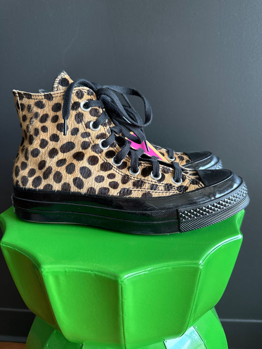 A pair of high-top sneakers with a leopard print pony hair upper, black laces, and black rubber soles, displayed on a bright green pedestal against a dark gray background. Sherwood Park consignment, Sherwood Park shopping, consignment store Sherwood Park, Edmonton consignment, secondhand shopping, secondhand clothing, women’s consignment, women’s clothing consignment, curated consignment, quality secondhand clothing, pre-loved clothing, thrift shopping, sustainable fashion, local shopping, Alberta consignme