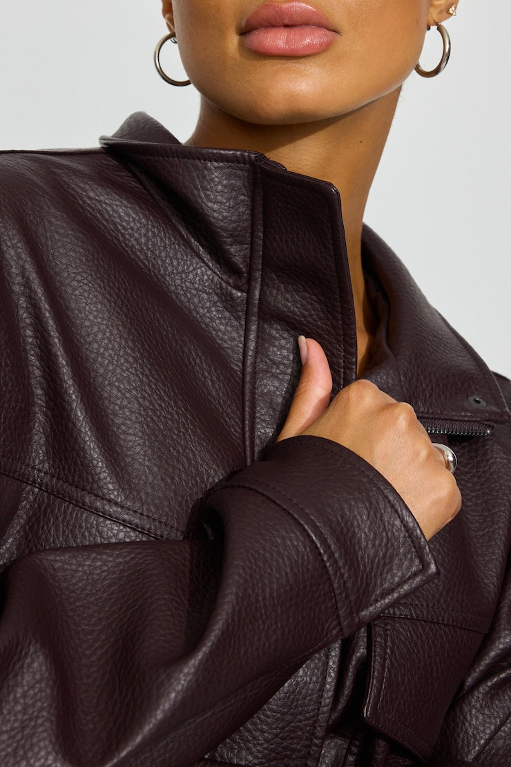 Close-up of a model wearing a dark wine pebbled faux-leather jacket, showing the collar, zipper, and textured fabric. Garage vegan leather. Sherwood Park consignment, Sherwood Park shopping, consignment store Sherwood Park, Edmonton consignment, secondhand shopping, secondhand clothing, women’s consignment, women’s clothing consignment, curated consignment, quality secondhand clothing, pre-loved clothing, thrift shopping, sustainable fashion, local shopping, Alberta consignment
